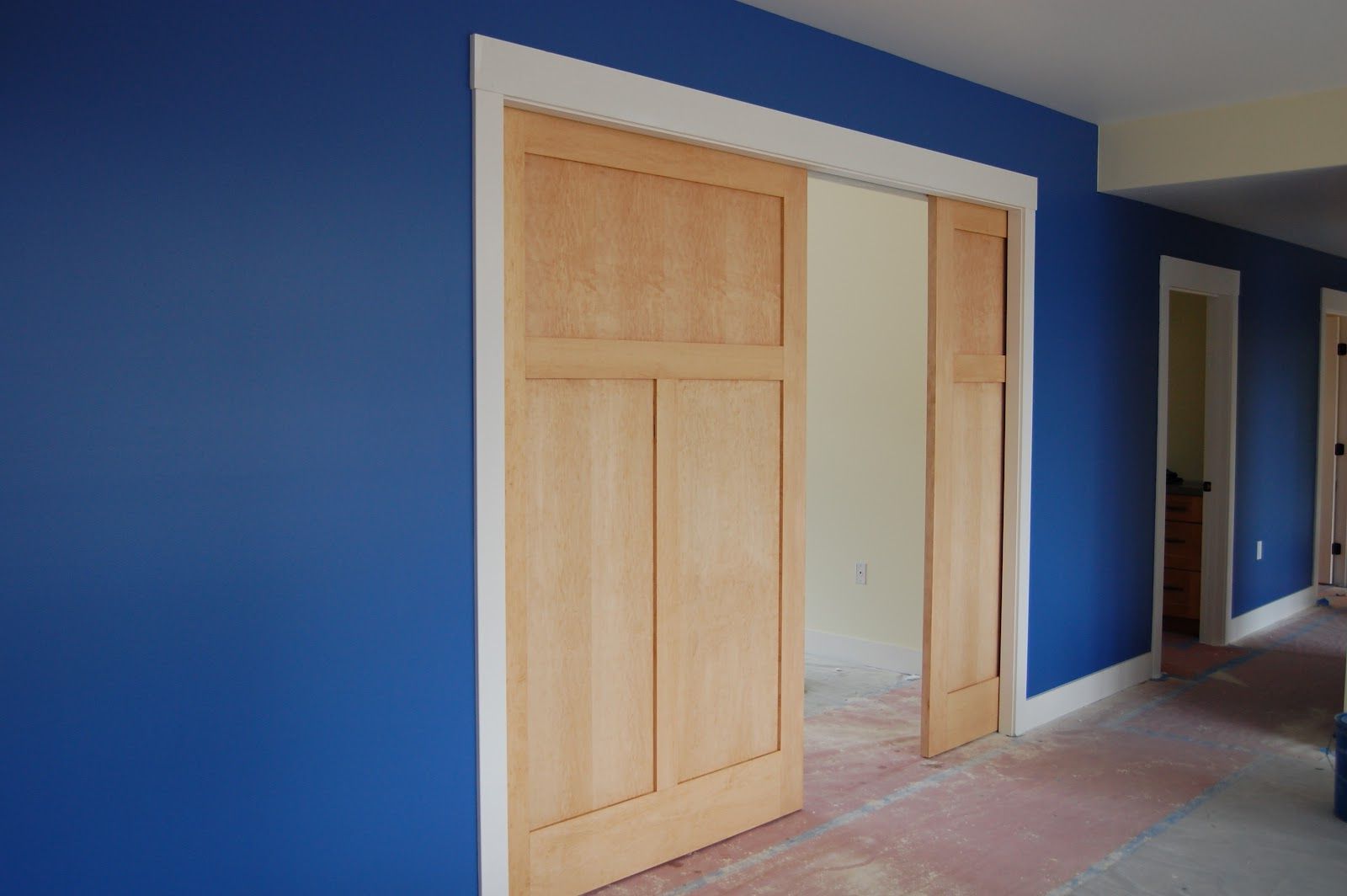 Large wooden pocket interior doors and blue walls in the room