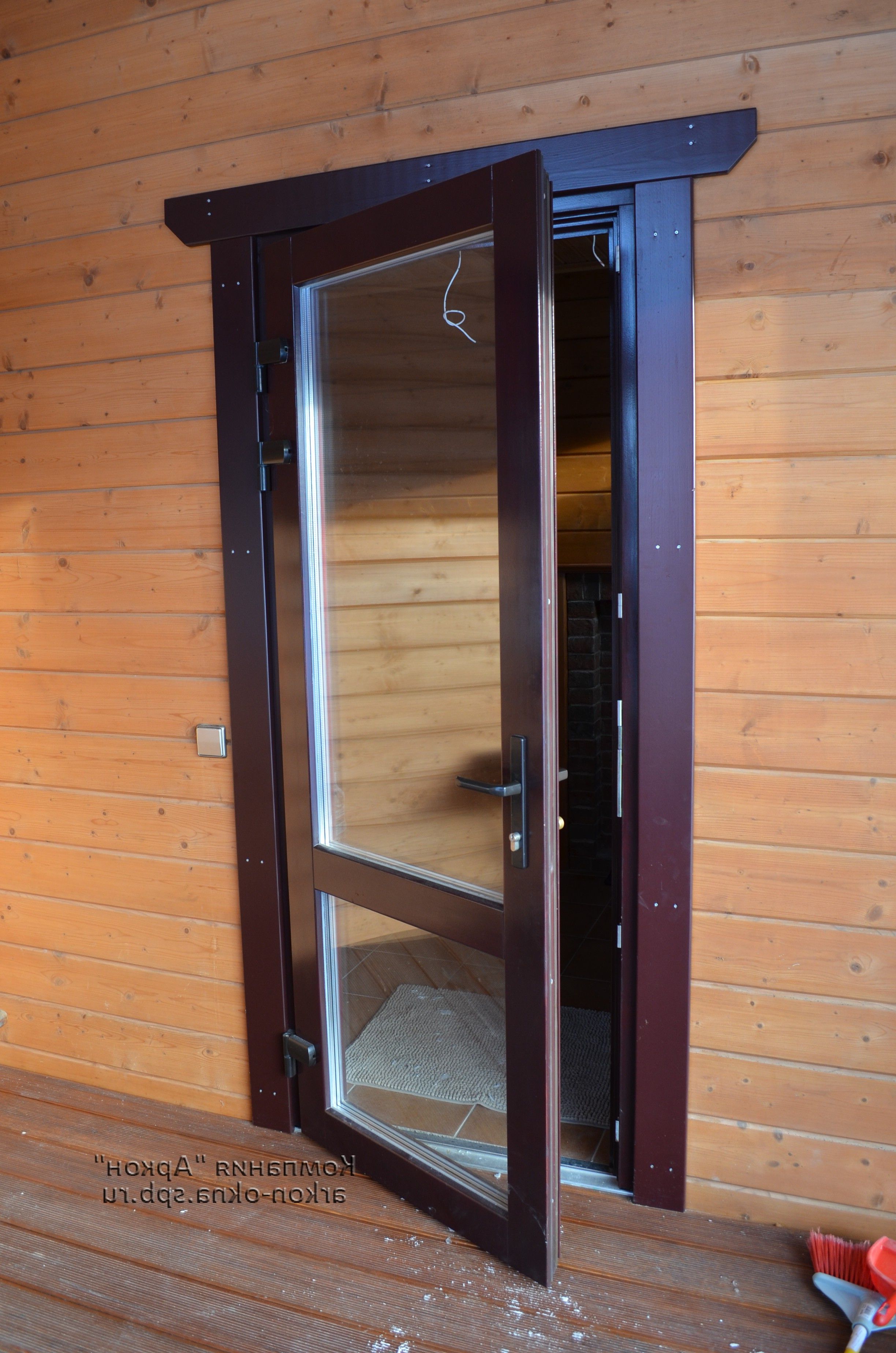 Plastic interior door with a large window in a wooden house