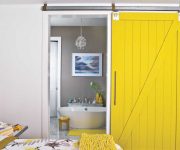 Wooden sliding interior door is painted in yellow color