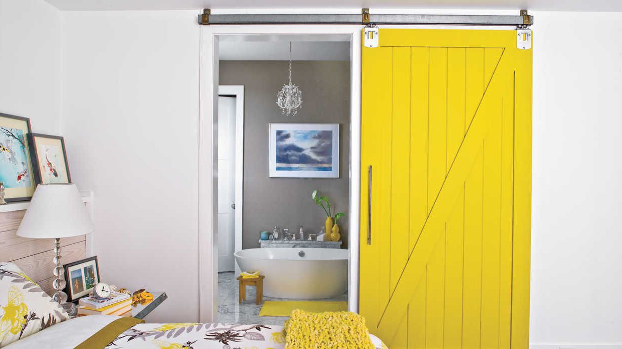 Wooden sliding interior door is painted in yellow color