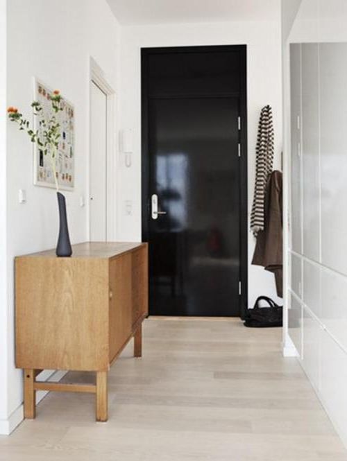 Black interior door with white walls and light floor