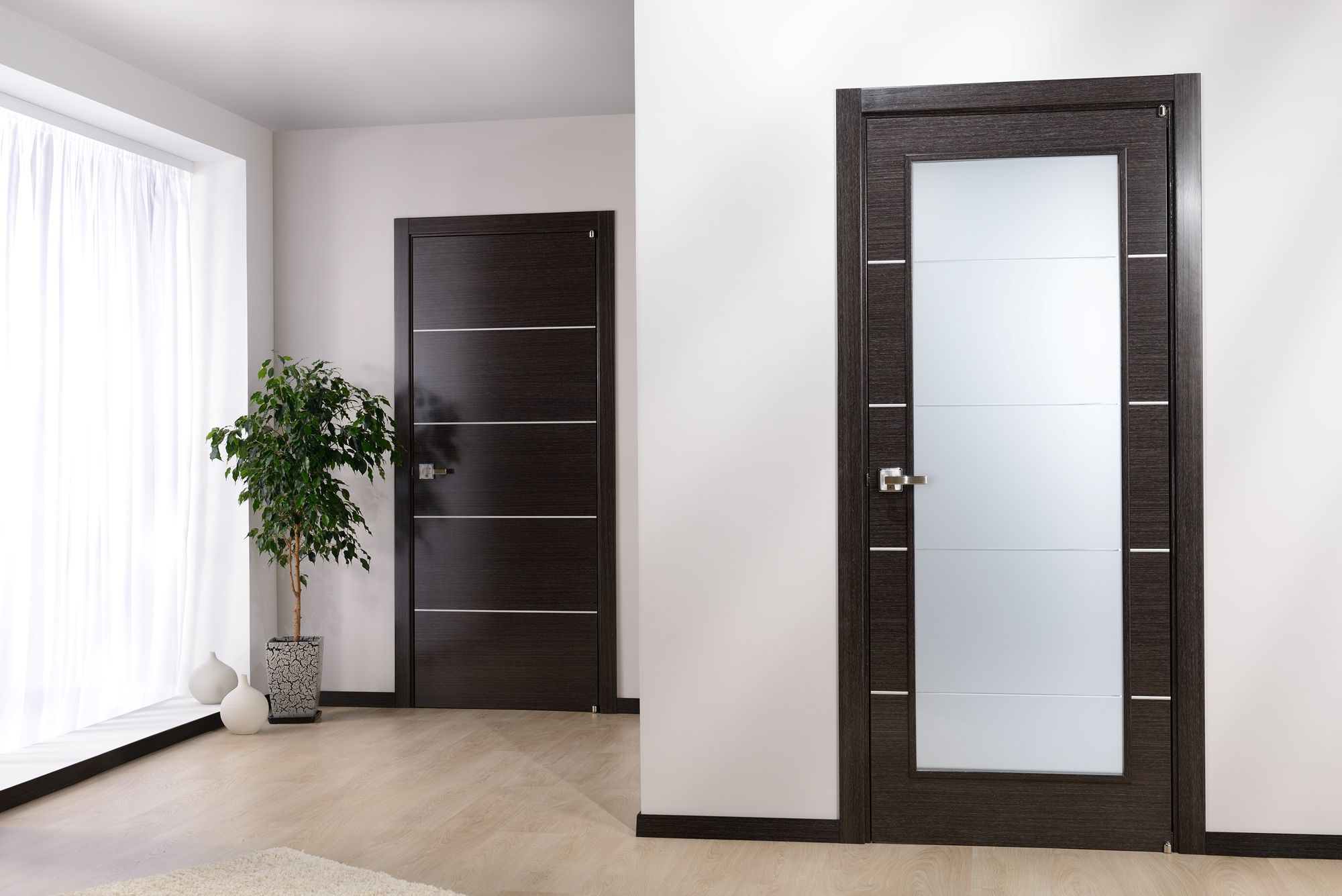 Modern dark door in an apartment with a light floor