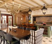 Antique ceiling lamps, wooden table and wicker chairs in the kitchen of an Italian style