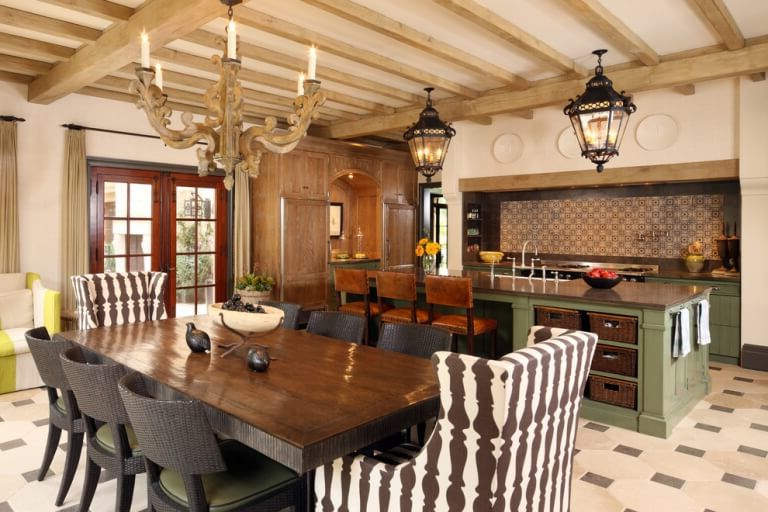 Antique ceiling lamps, wooden table and wicker chairs in the kitchen of an Italian style