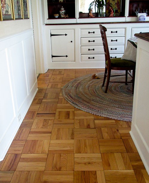 Floor parquet boards and white furniture in the country style kitchen